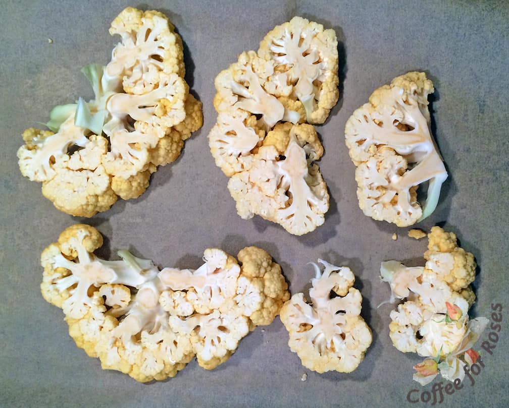 Place the sliced pieces of cauliflower carefully on a parchment-lined cookie sheet. Roast at 375 degrees for about a half hour, until they are soft enough to pierce with a fork but not falling apart or mushy.