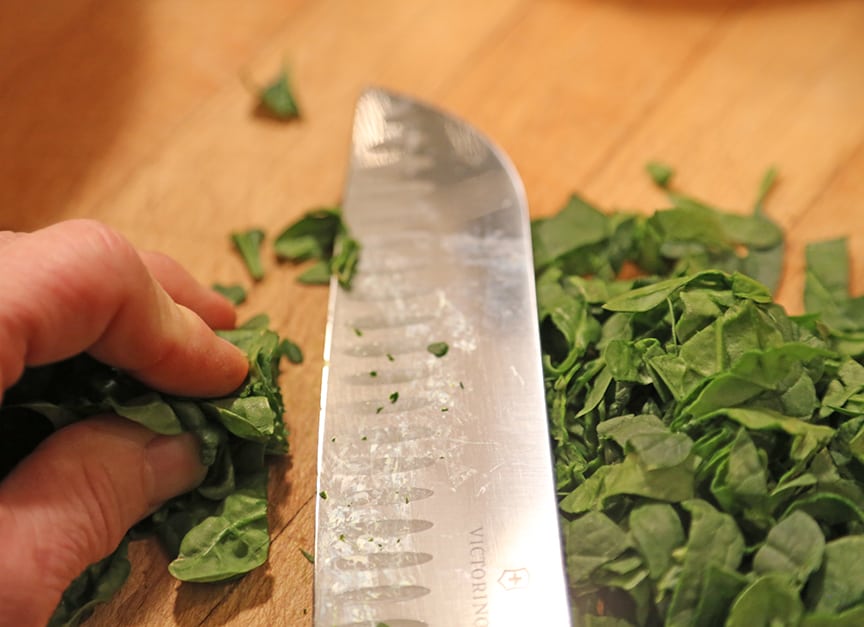 Chop the baby spinach by gathering it in one hand and chopping the pile with the knife in your other hand...being careful not to chop your fingers, of course.