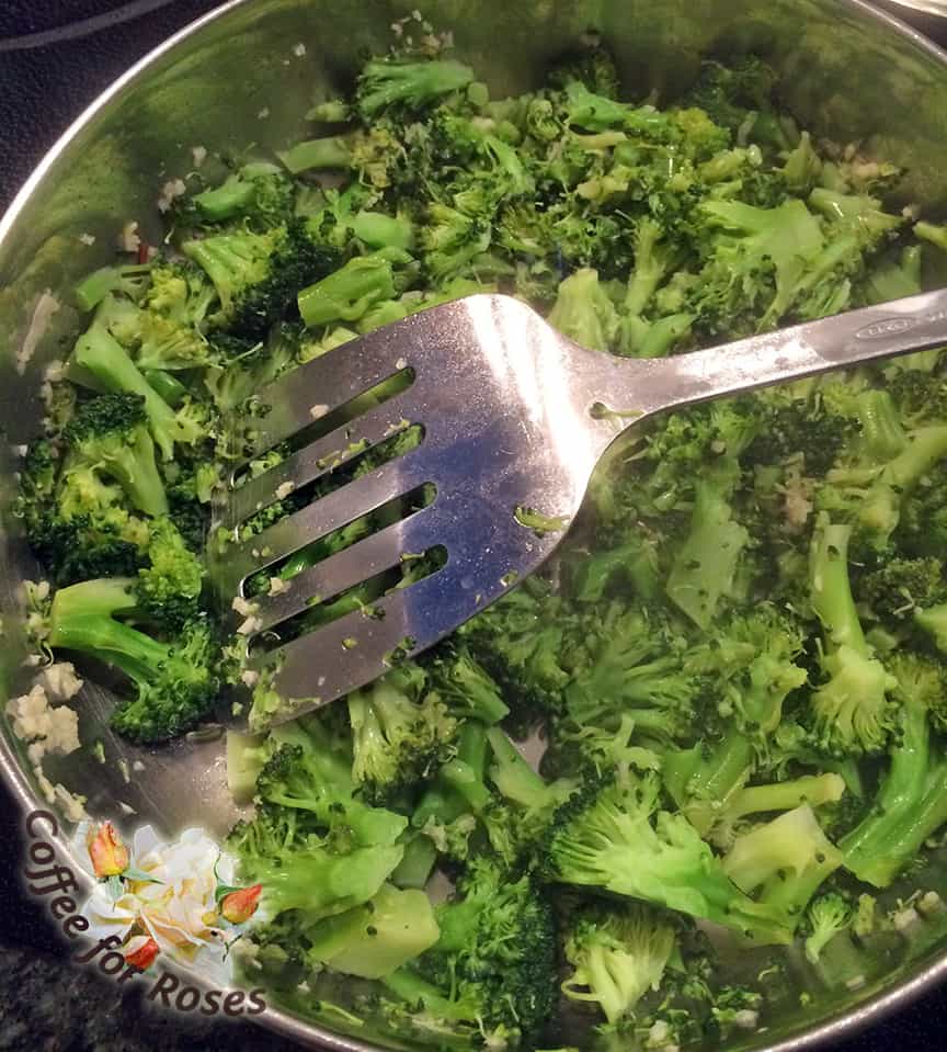 The broccoli starts out bright green. You can use the edge of the spatula or other cooking tool to both stir and chop the broccoli as it cooks.