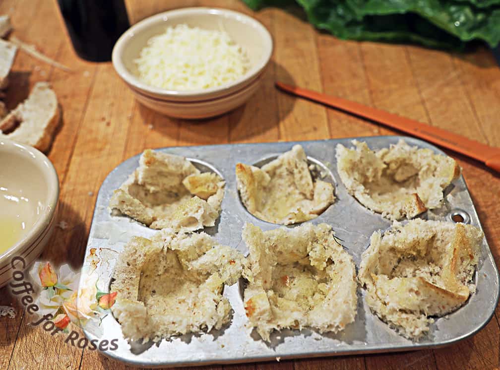 Grease a muffin tin and push the bread squares into the cups.  
