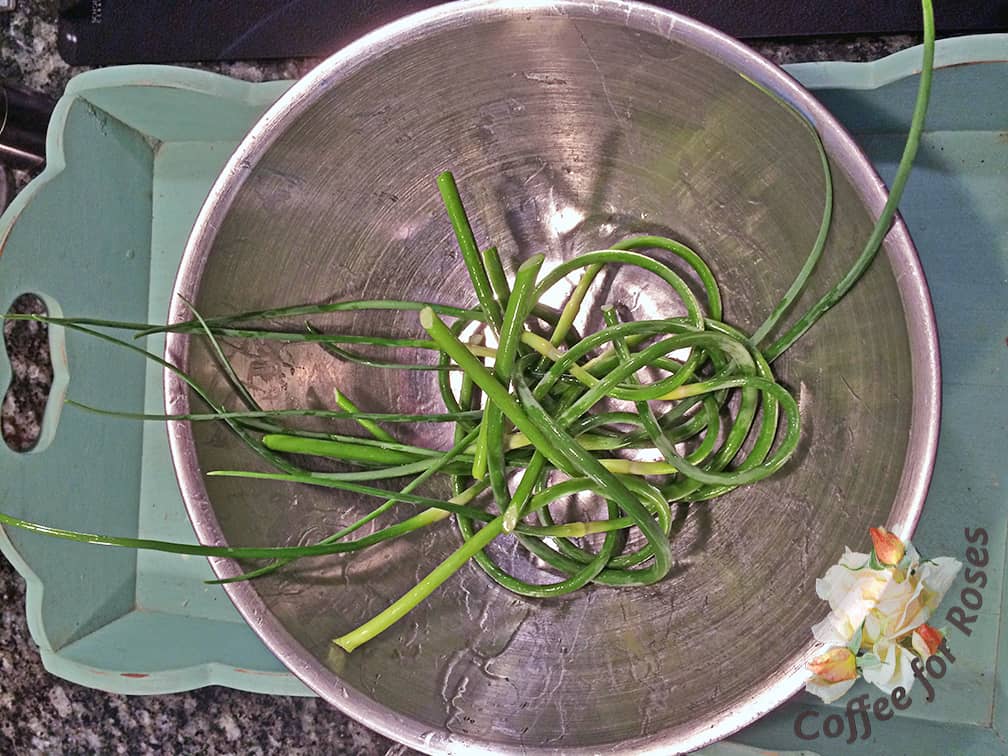 Cut all the scapes off of your garlic plants and store them in the refrigerator until ready to use. If you're grilling, just pile some of the scapes into a bowl and toss with a tablespoon of olive oil.