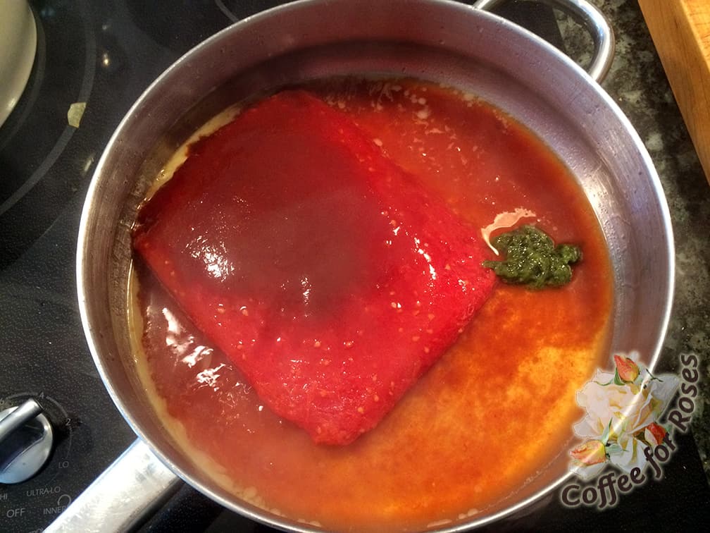 Put the canned or frozen tomatoes into a pan with the adobo sauce and about a tablespoon of the cilantro paste. Cook these down for about ten or fifteen minutes over medium heat.