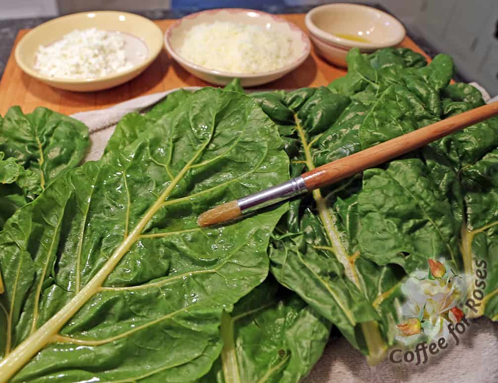 Begin by brushing (or spraying) three large leaves with oil on one side.