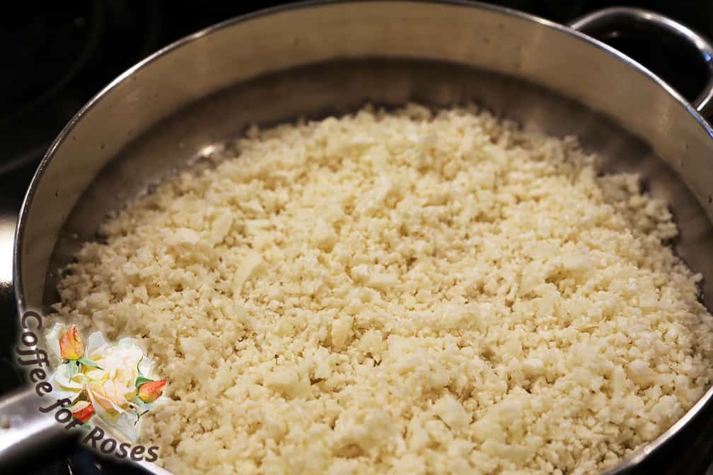 Chop the cauliflower in a food processor in several small batches using quick bursts on and off so that you don't end up chopping it too fine. Aim for pieces slightly larger than rice, and you'll get a good mix of small pieces that don't turn into mush.