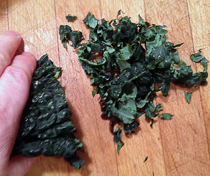 I put a stack of about six to eight leaves together, hold them firmly with one hand and slice the kale into ribbons with a sharp knife.