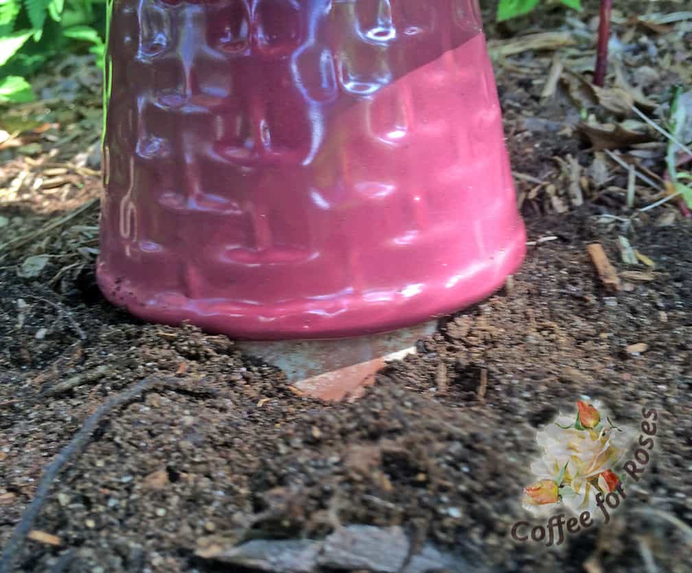 I found an old terracotta flower pot that had a bottom the right size to fit into my colorful pot. I then buried the top 2/3 of the terracotta pot in the ground. The bottom colorful pot slipped over the terracotta pot so that the tower is securely held upright in the garden.