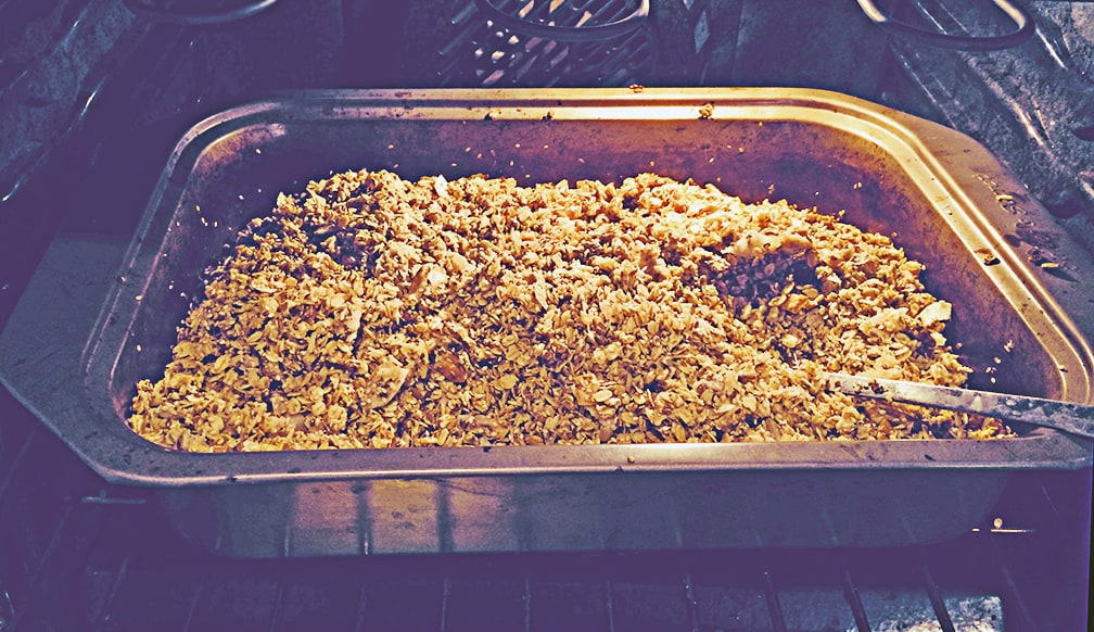 Stir the granola about every 10 minutes while it's in the oven. Be sure to scrape it away from the sides of the pan where it will brown more quickly, as well as up from the bottom. Once it's been in the oven about 30 minutes you might want to stir more frequently as it will start to brown more quickly.