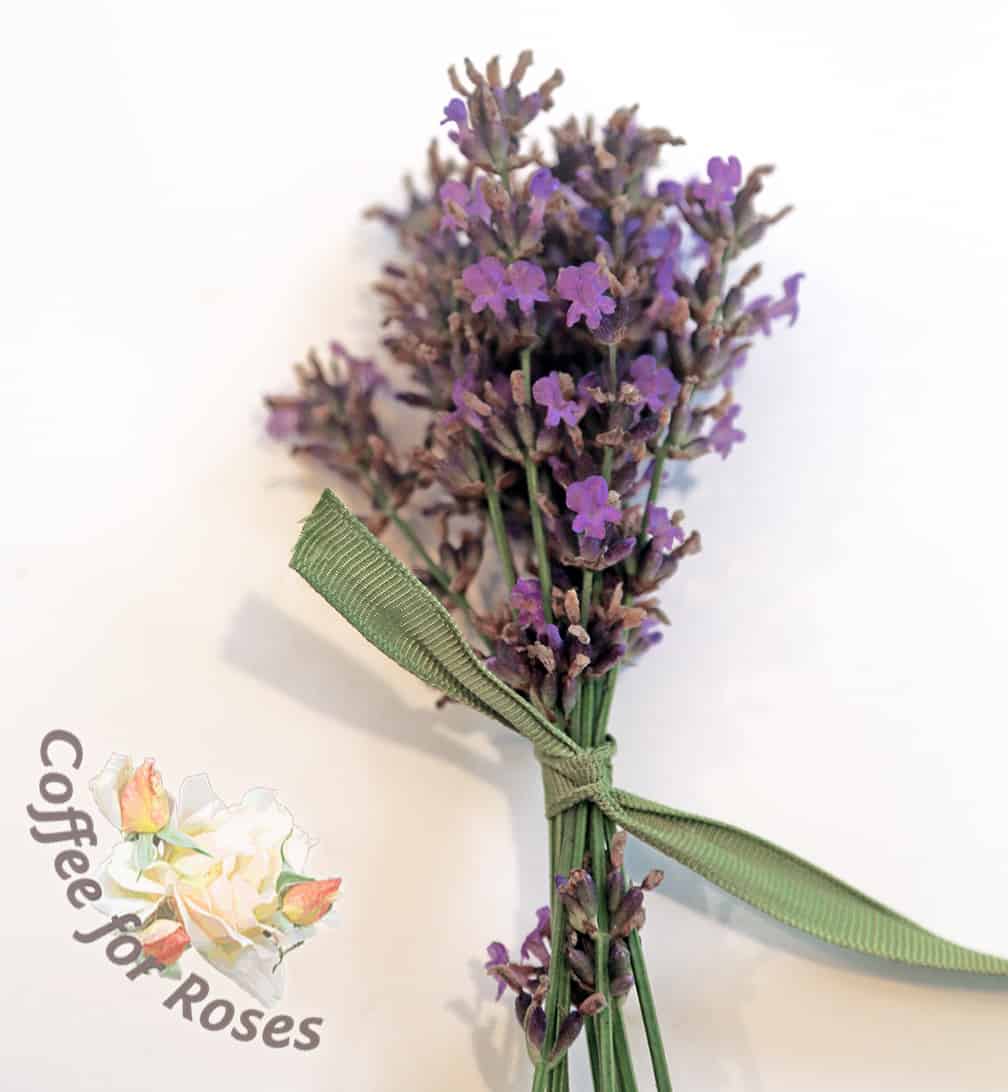 Measure out a ribbon that's about 3/8 inch wide and four feet long. Tie one end around the bunch of lavender, clustering all the flowers together at the same height, more or less. 