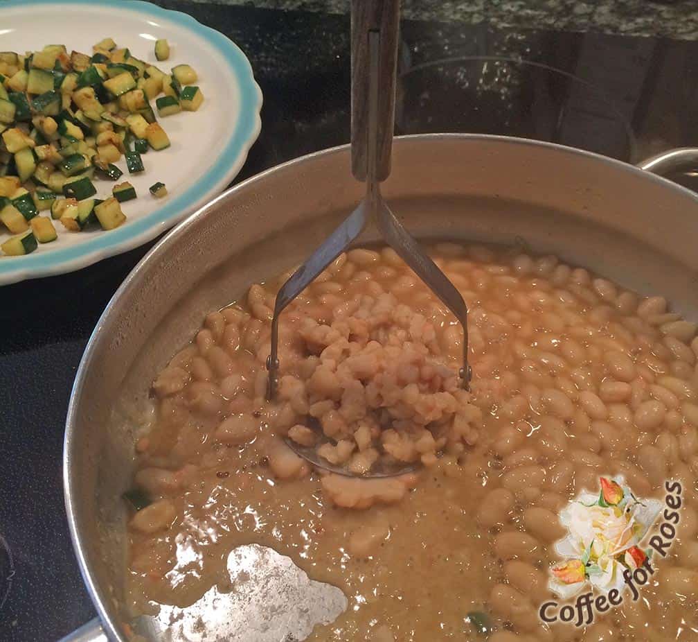 Use a potato masher or the back of a large spoon to mash the beans and garlic together, making it just a bit creamy. 