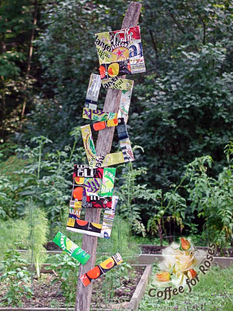 This colorful totem is made from tin-can art on a large limb.